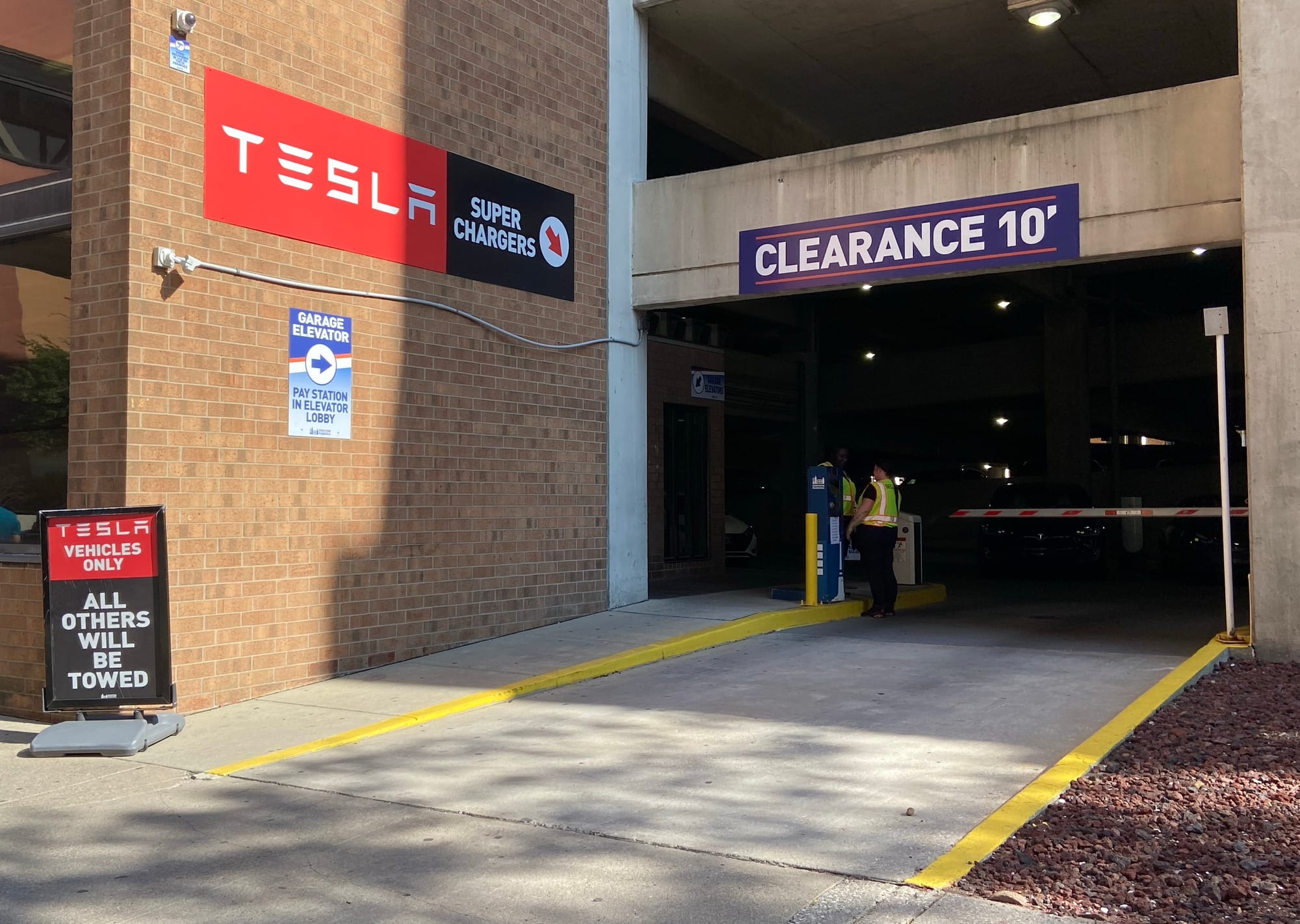 The entrance to a garage has a sign reading "Tesla vehicles only; all others will be towed."