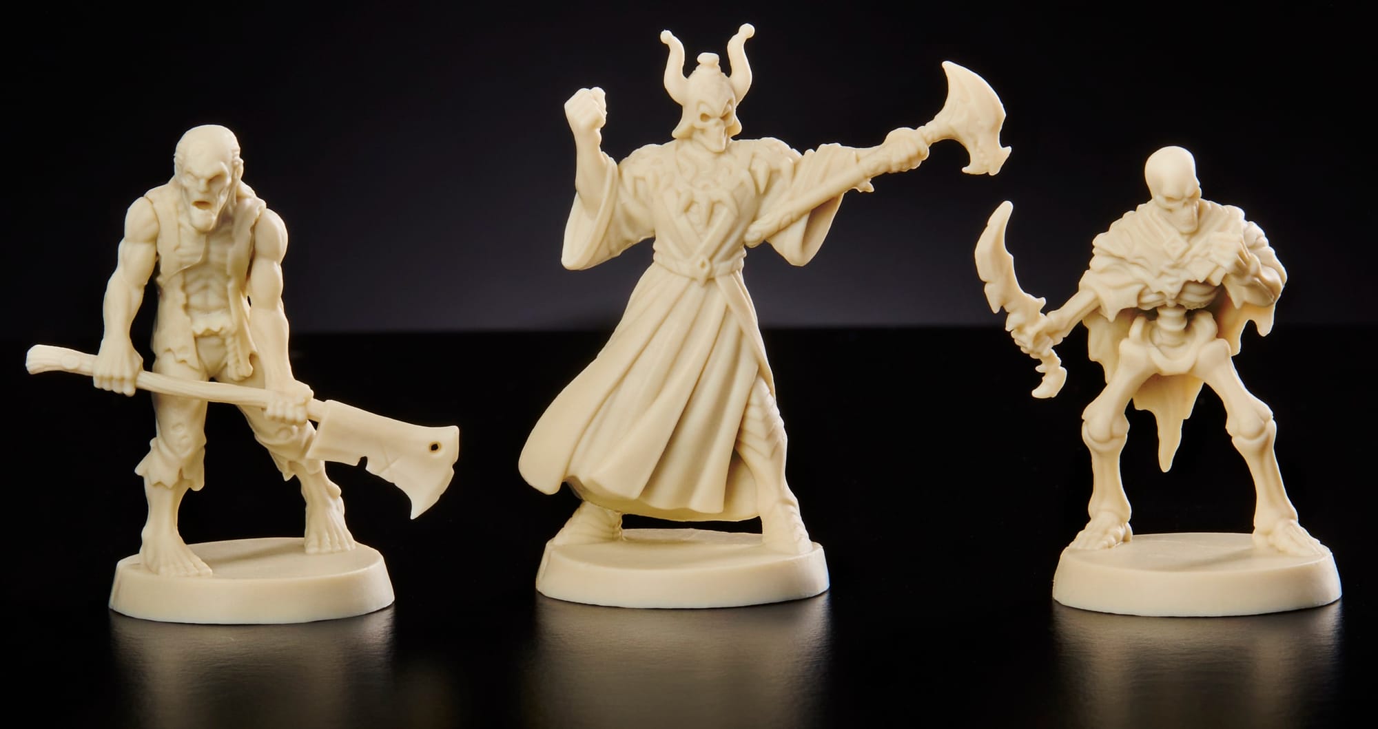 Three game miniatures in white plastic are depicted, each a different fantasy creature.