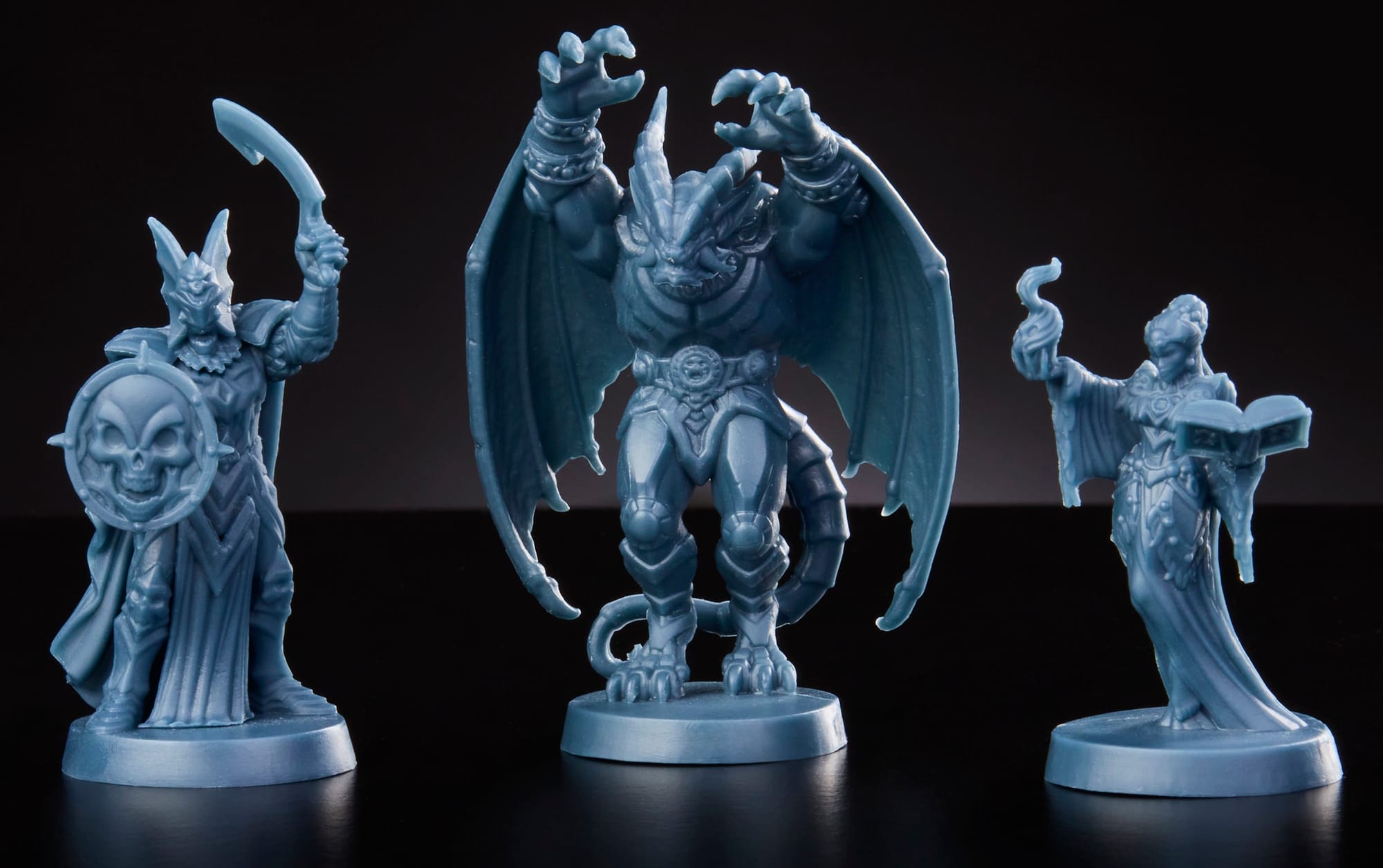 Three game miniatures in blue plastic are depicted, each a different fantasy creature.