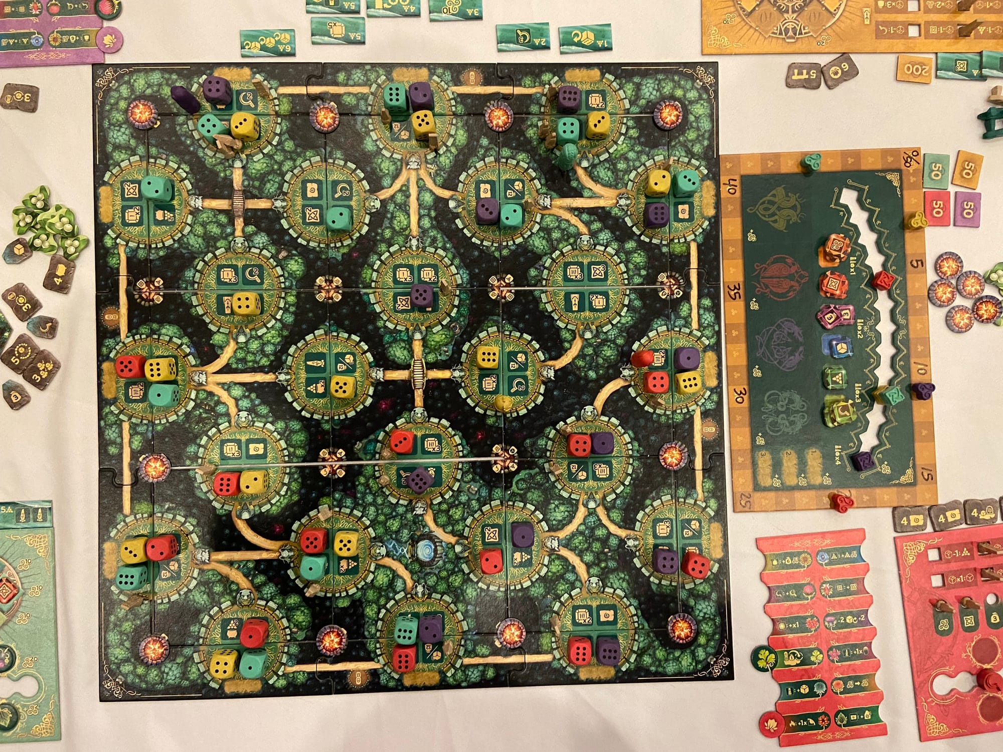 Another layout of the game board, showing sites, forests, clearings, with four colors of dice on various sites.