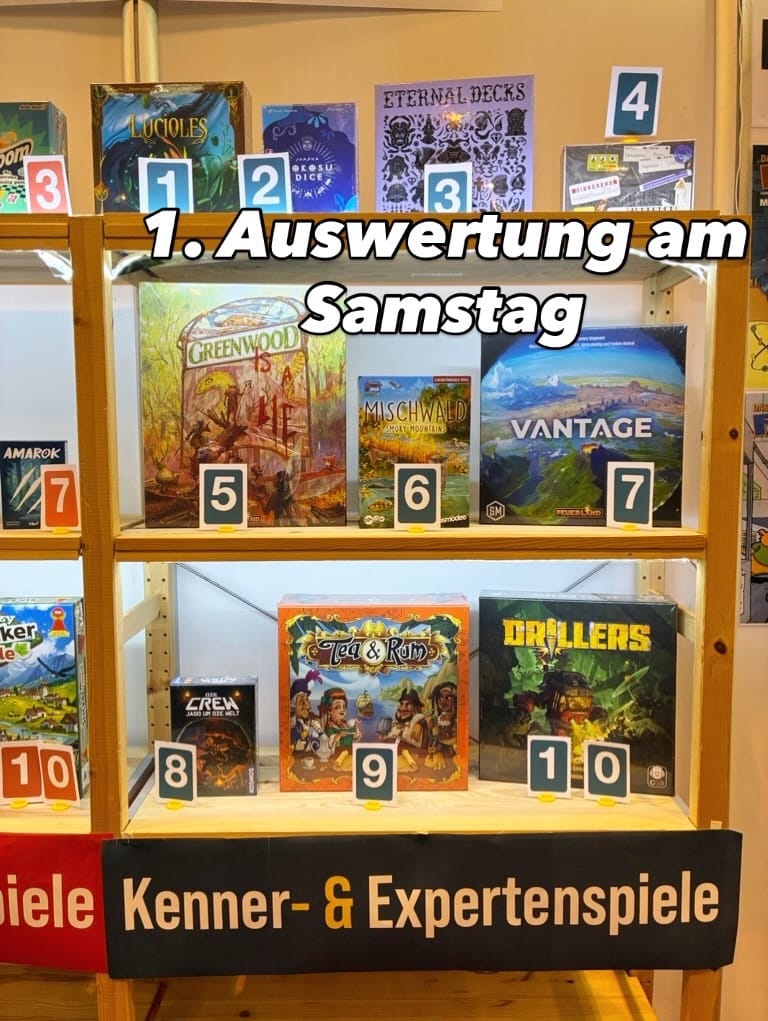Ten games are on wooden shelves numbered #1-10. In order: Fireflies, Nokosu Dice, Eternal Decks, Gibberers, Greenwood, Forest Shuffle: Smoky Mountains, Vantage, The Crew III, Tea & Rum, and Drillers.