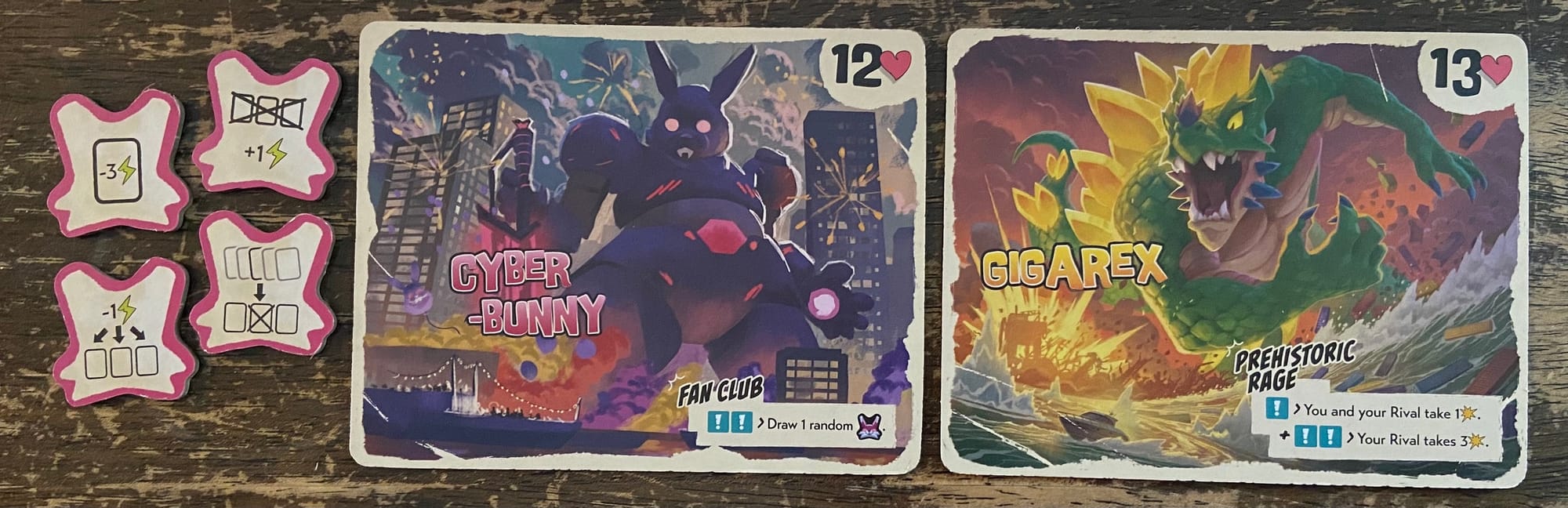 Two monsters in King of Tokyo: Duel – Tokyo Bay, with Gigarex causing one damage to each monster, then causing three damage only to the opponent.