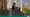Depicted: a large dog stands on its hind legs with its front paws over a deck railing, with the dog looking over a fence at the viewer