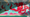 A red octopus the size of twenty-story office buildings has its tentacles wrapped around said buildings