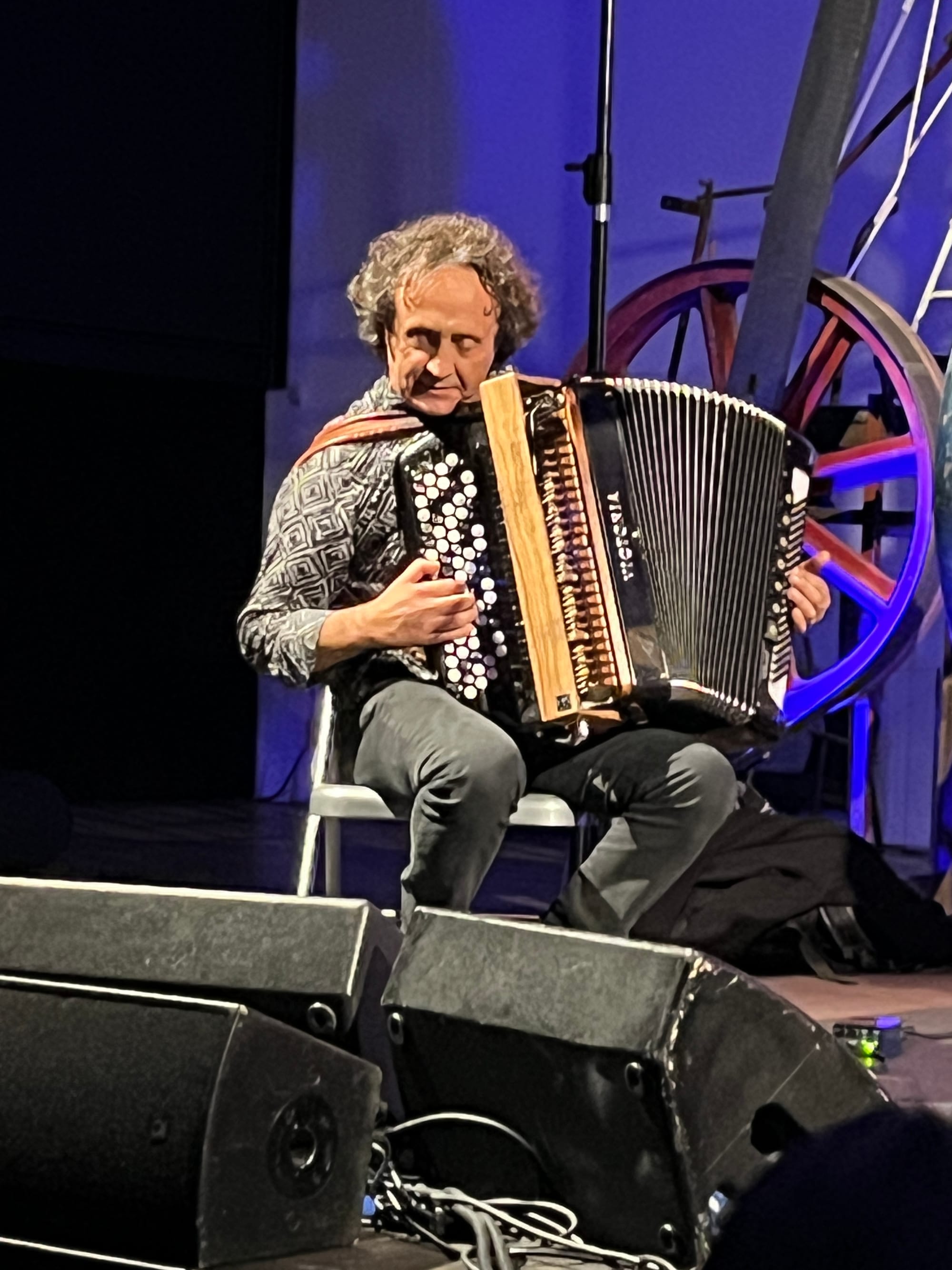 A man plays accordion, looking closely at the keys