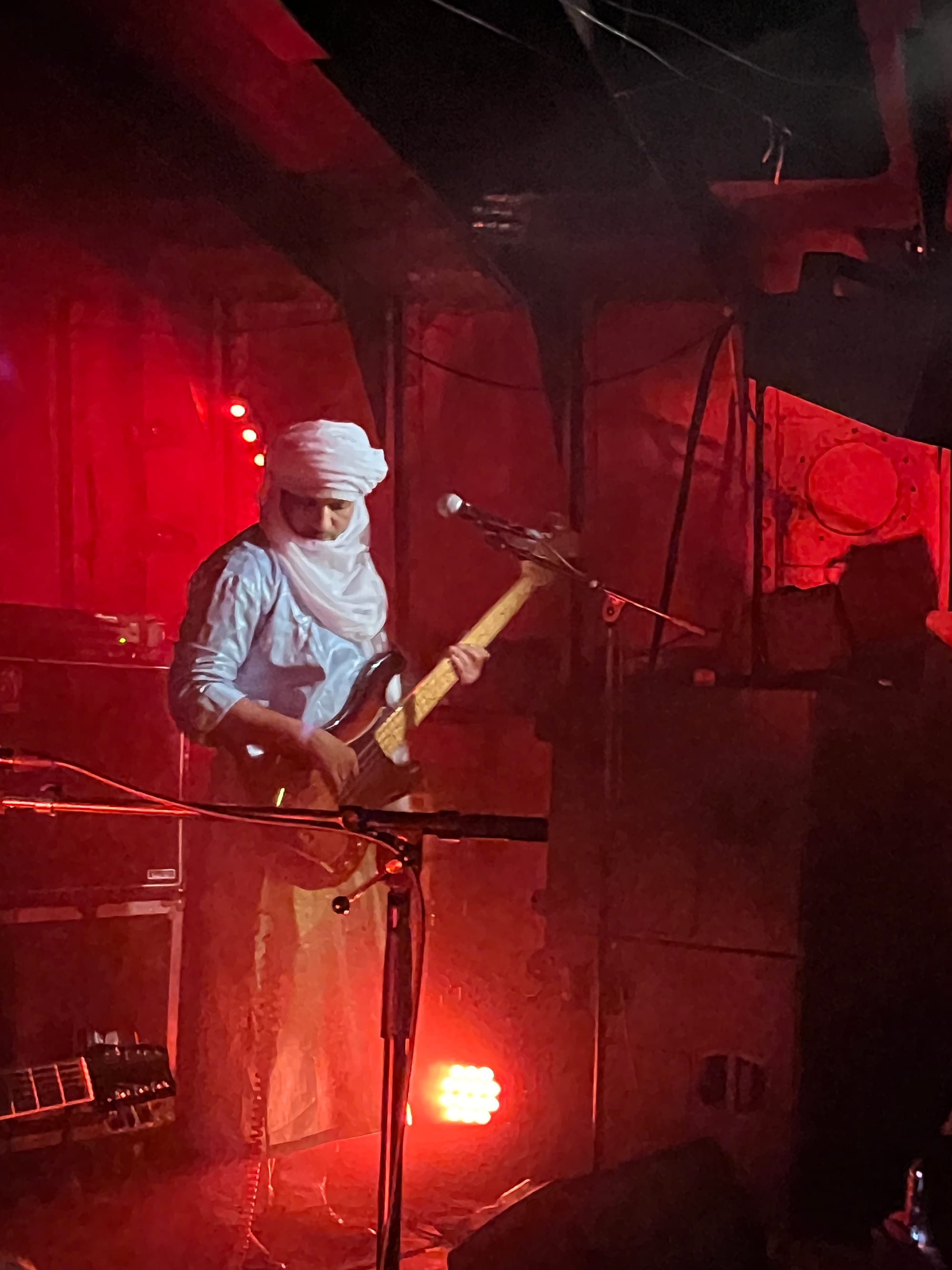 Cheikh ah Tiglia on bass in a blue robe with a white headdress.