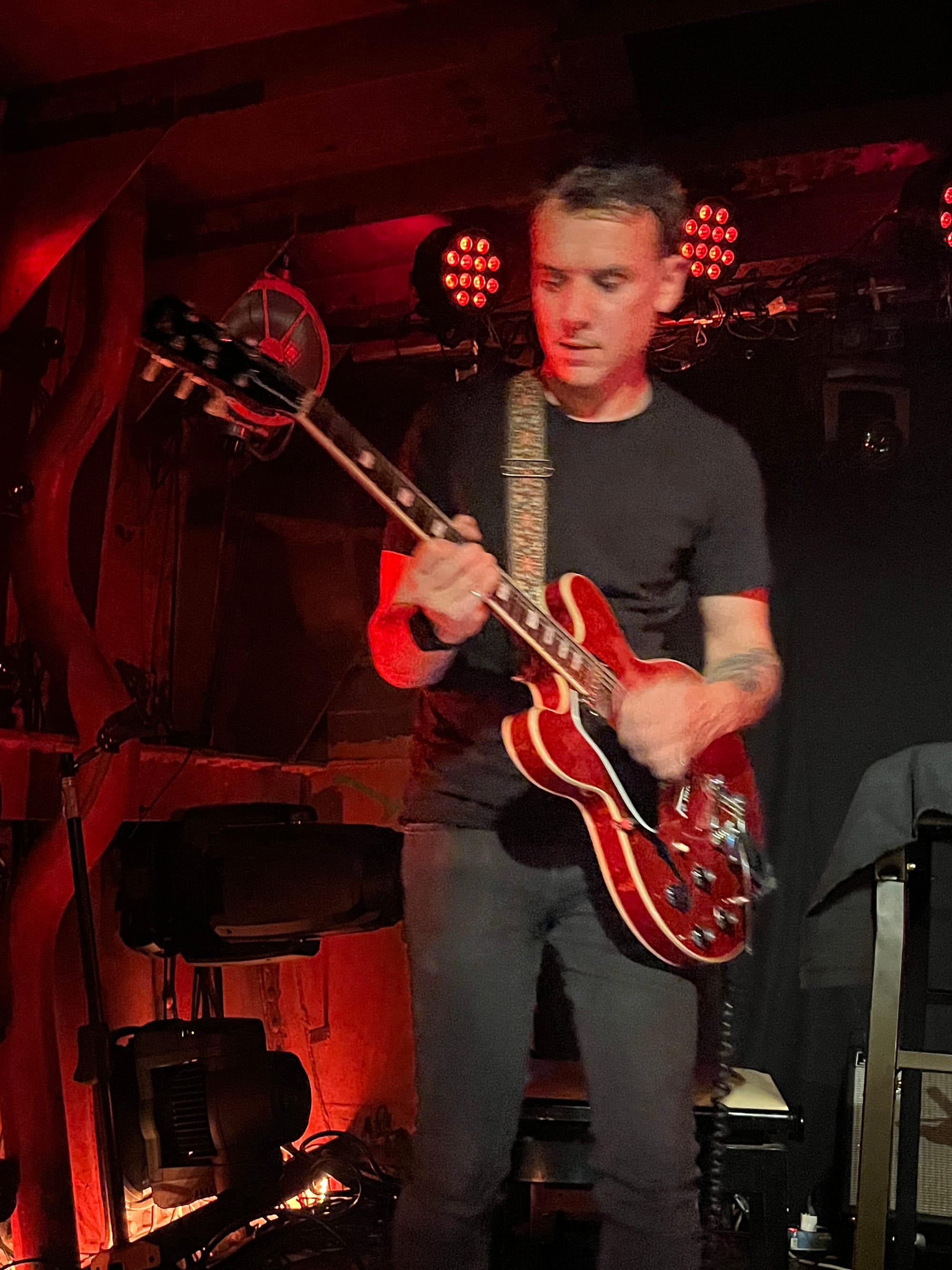 Paul Salvagnac on his red Gibson guitar, strumming a chord to play that perfect groove.