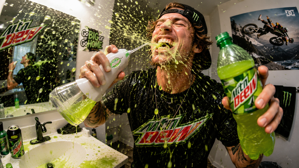 A guy flossing with Mountain Dew