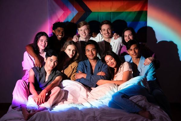 A bunch of people on a bed with "bisexual lighting"