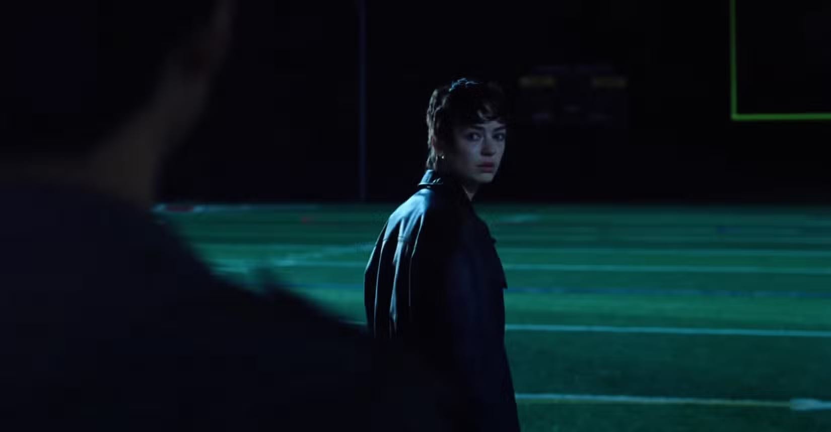 scene from i saw the tv glow where the character maddy is looking back at owen on the football field
