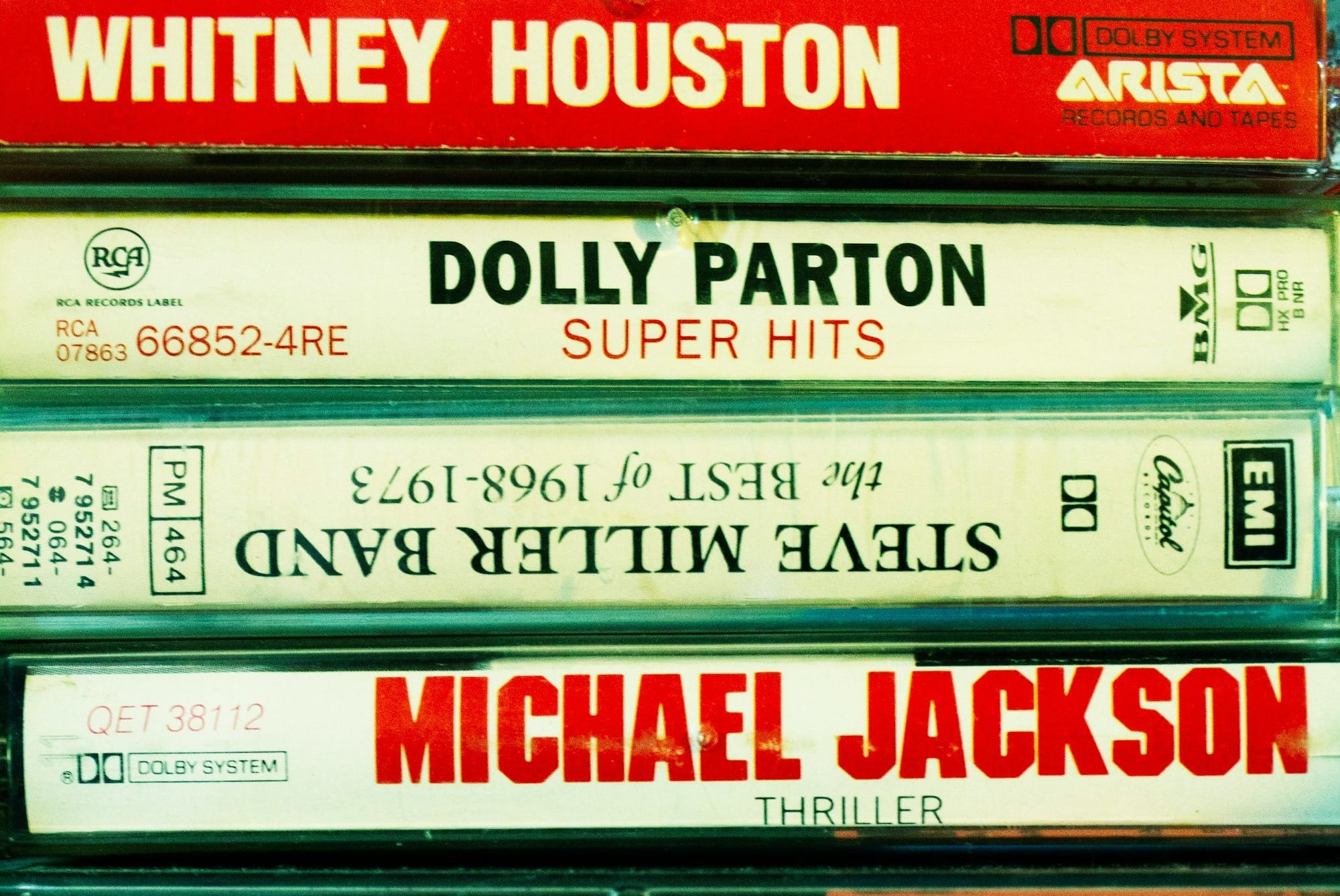 Stacked vintage music cassette tapes by various artists