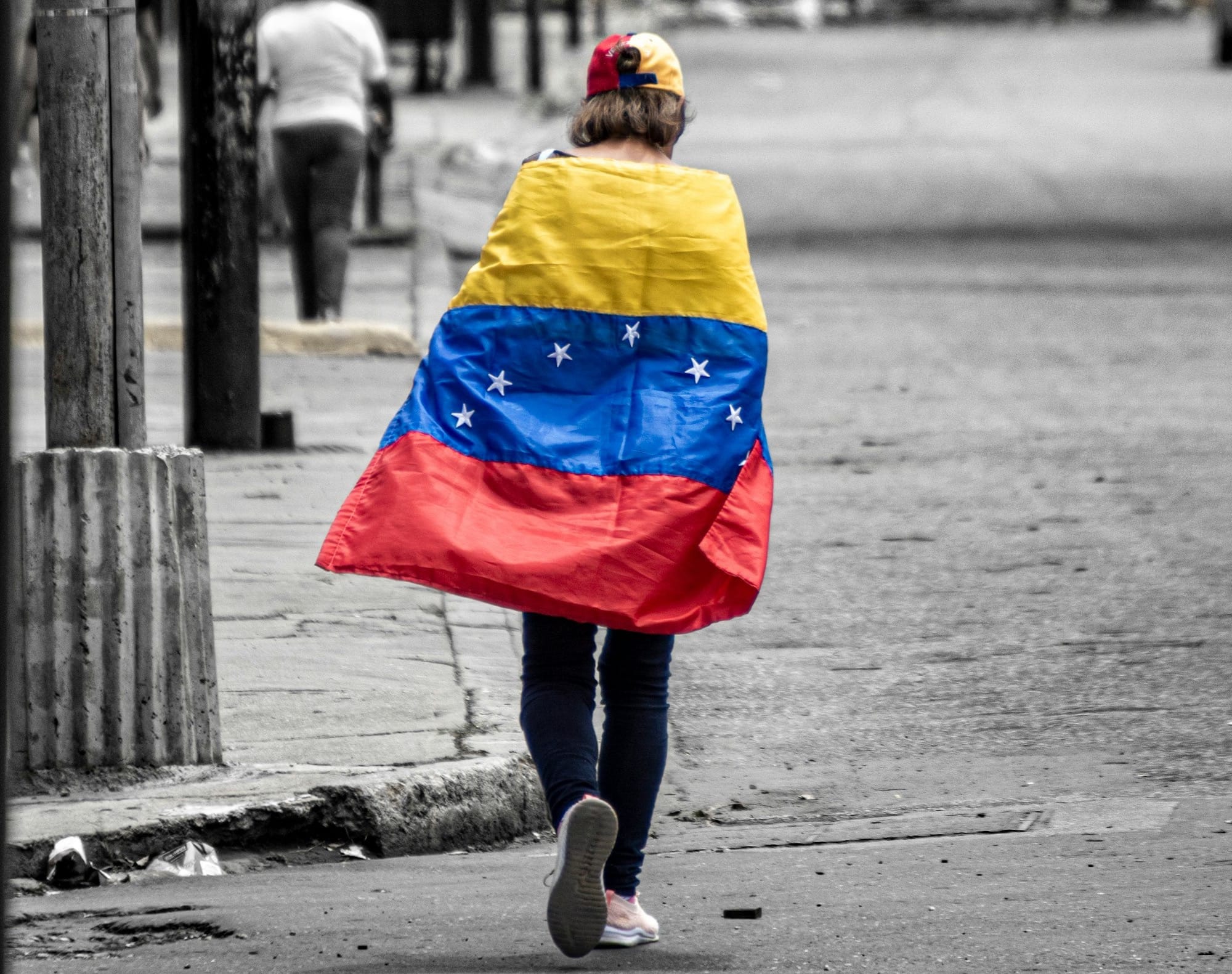 A person walking down a street holding a flag