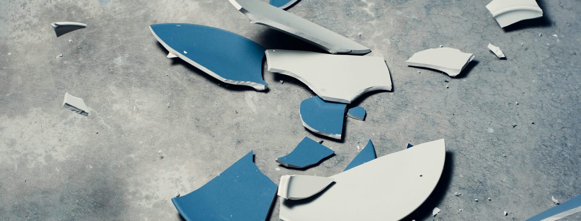 Broken blue plate on a gray background.