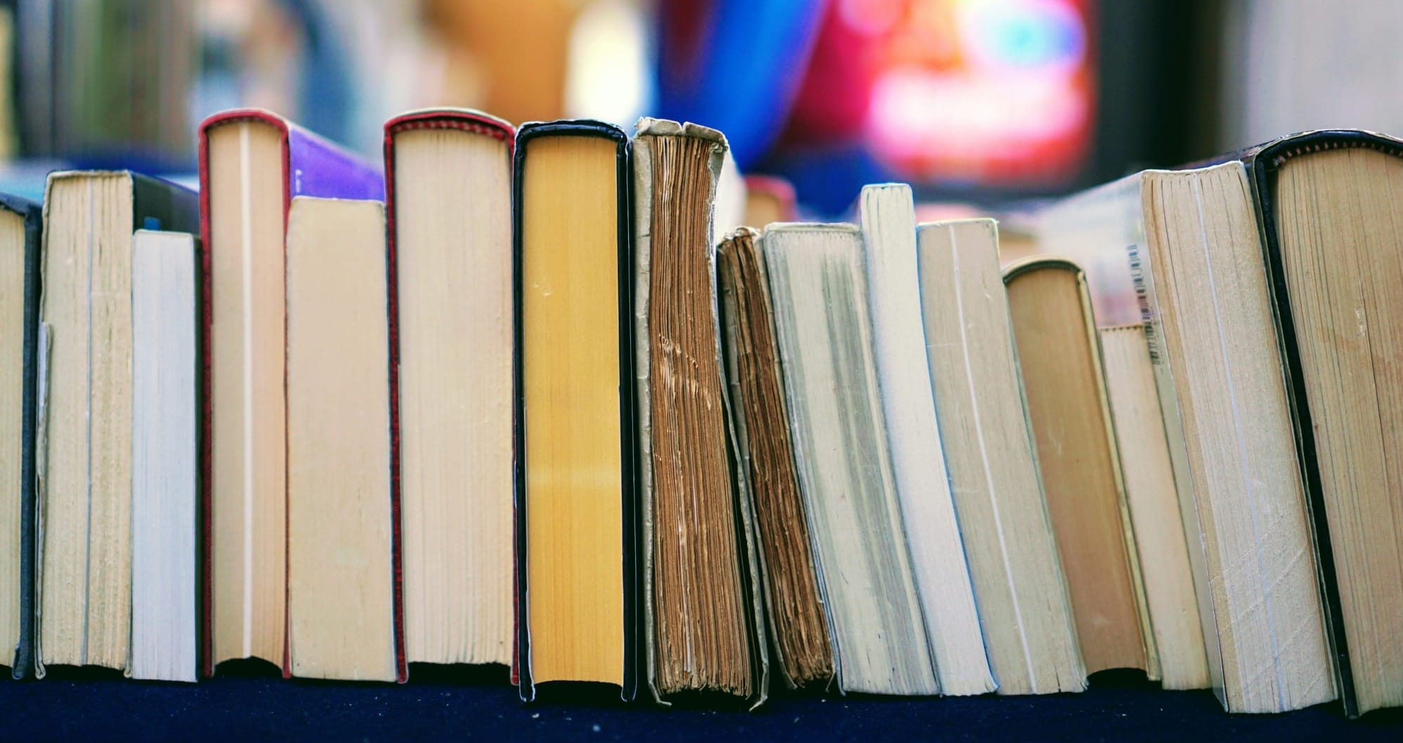 A row of old and new books viewed from the bottom.