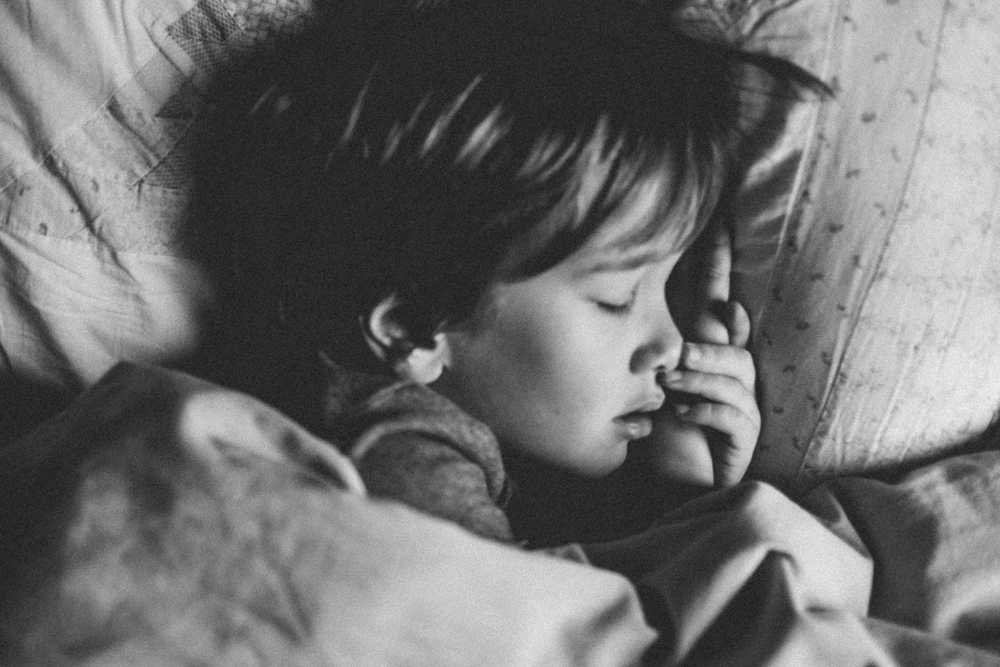 A child sleeps soundly on a puffy pillow.