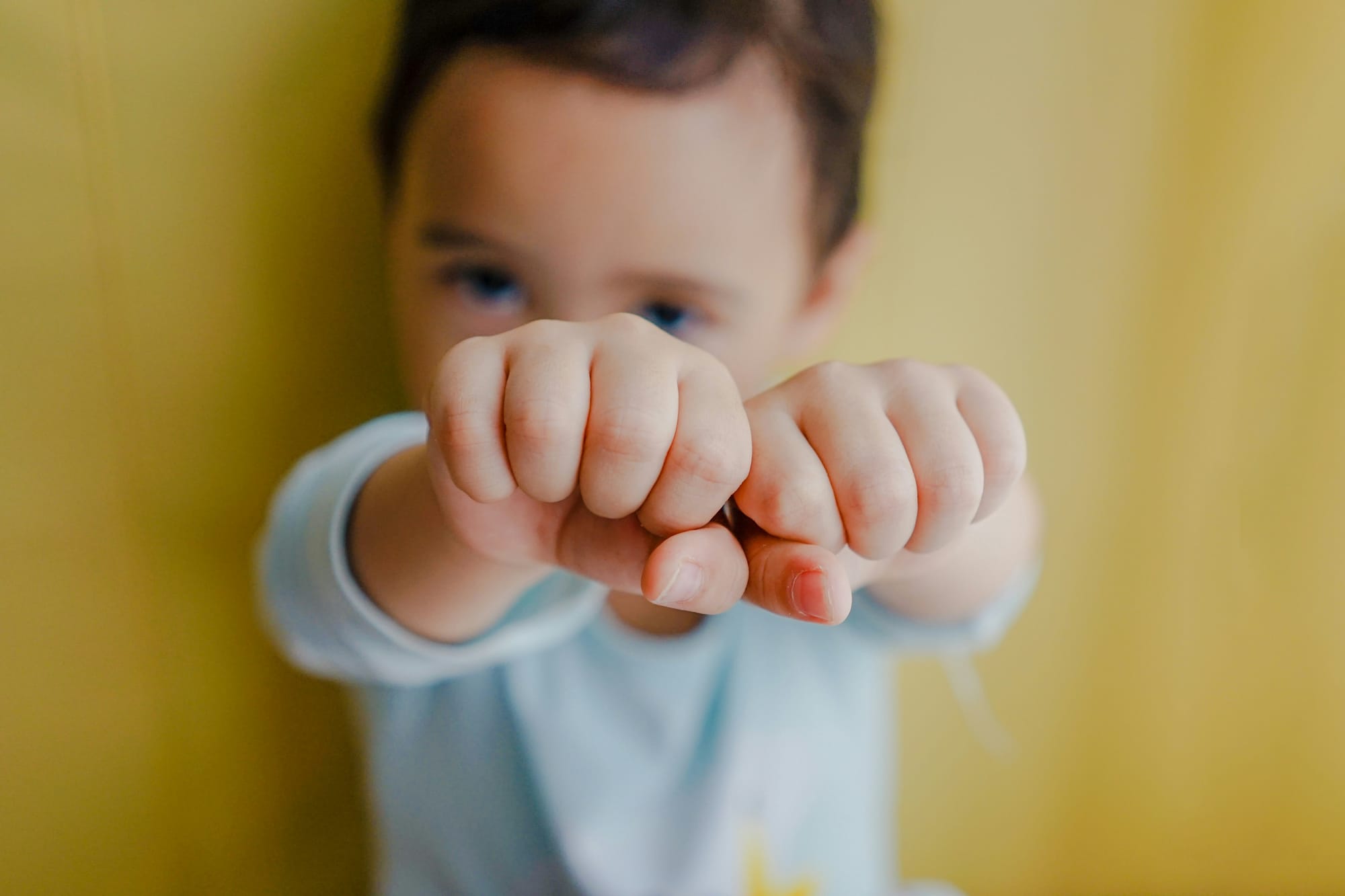 A baby with its fists held high. 