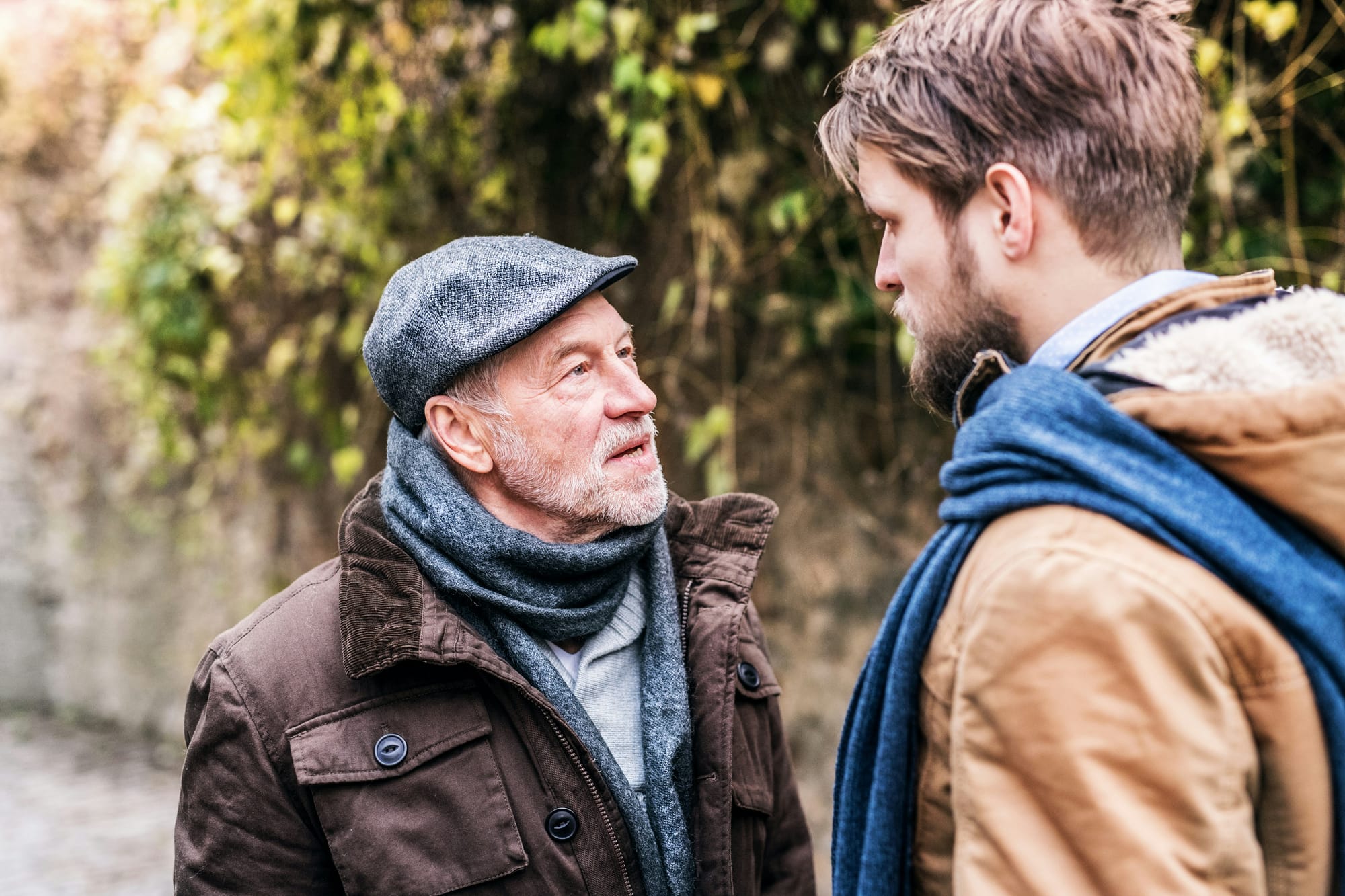 An older man and a young one in close up, seeming to disagree about something. 