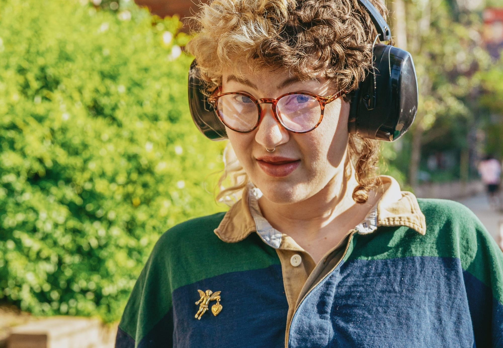 Per Unsplash: "Portrait of a nonbinary autistic person outdoors using headphones."