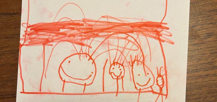 Young child's drawing of a family. All the family members are smiling. 