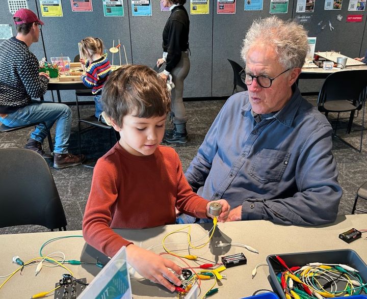 A grandfather and grandson work on electric circuits (thank you Bakken Museum!). 