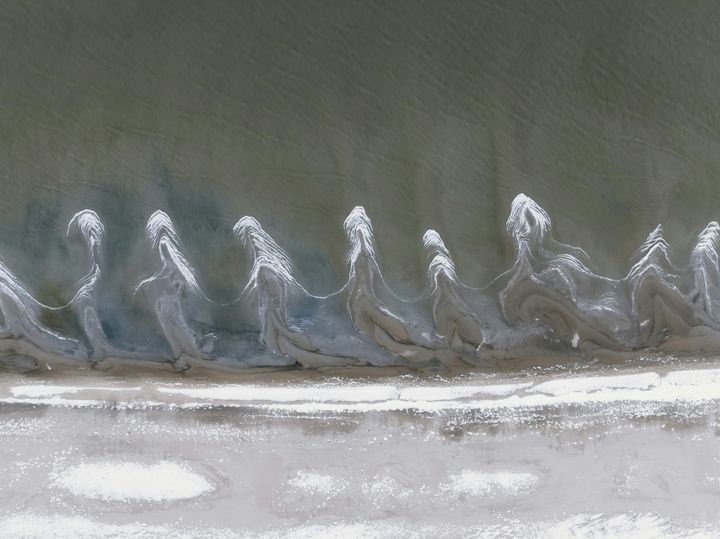 Abstract waves resembling stylized human forms.