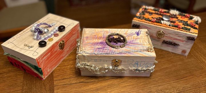Three small wooden boxes decorated with pencil, costume jewelry, and decoupage by our grandchildren.