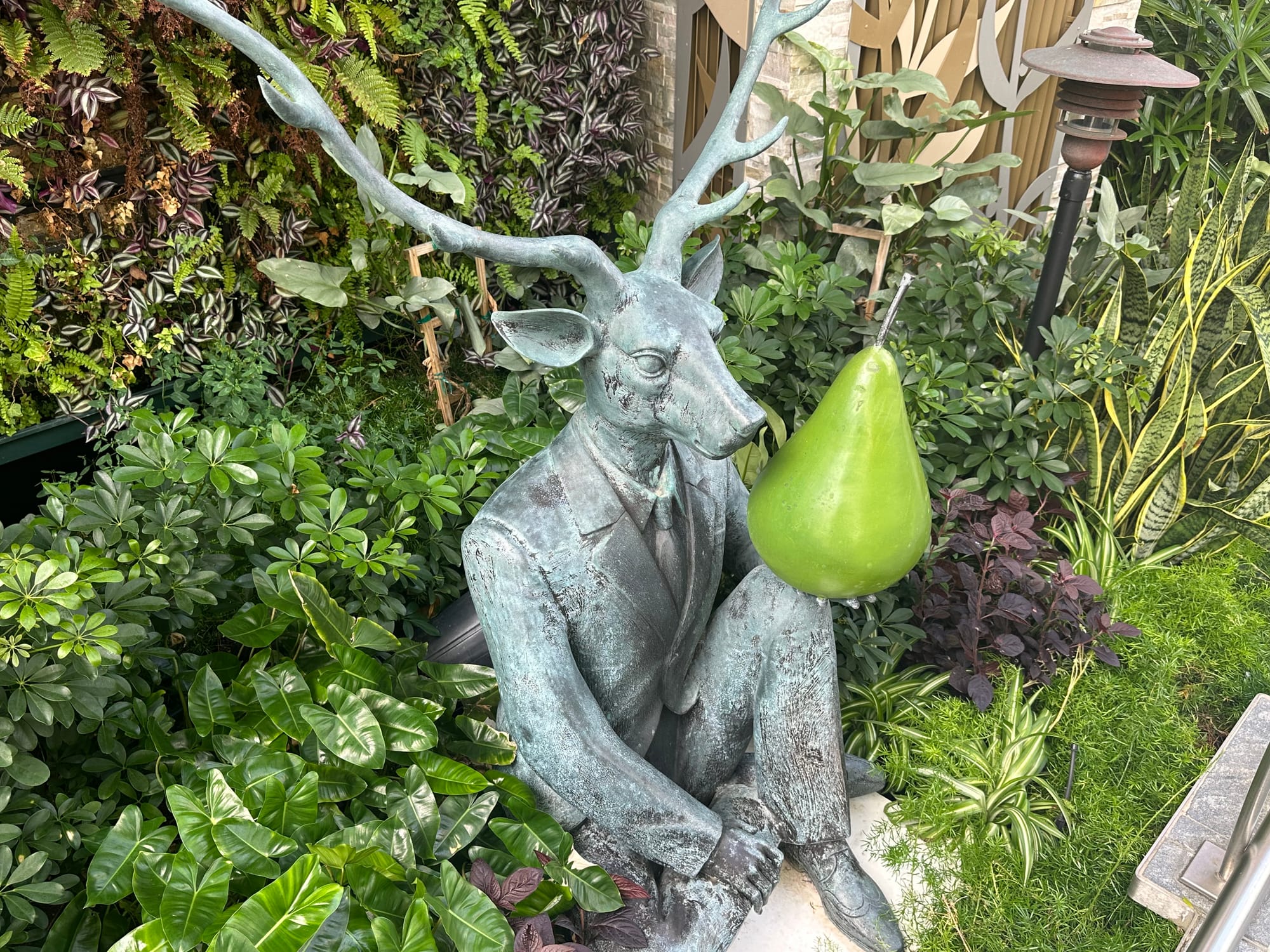A sculpture of a buck holding a pear