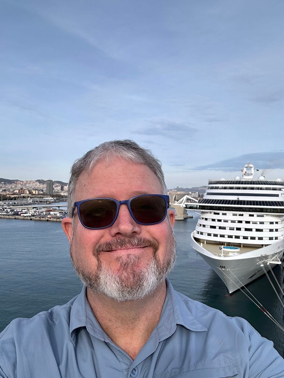 A man poses in front of a cruise ship in Barcelona