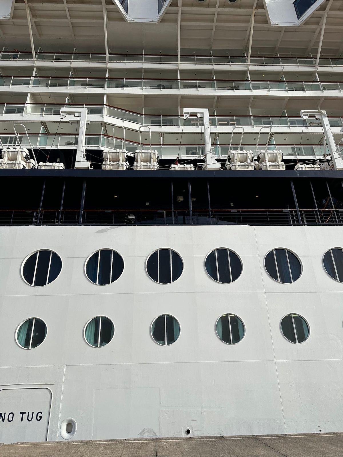 The side of a cruise ship with portholes
