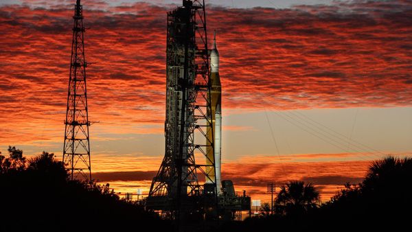 NASA's SLS rocket and Artemis 2 Orion spacecraft at sunrise