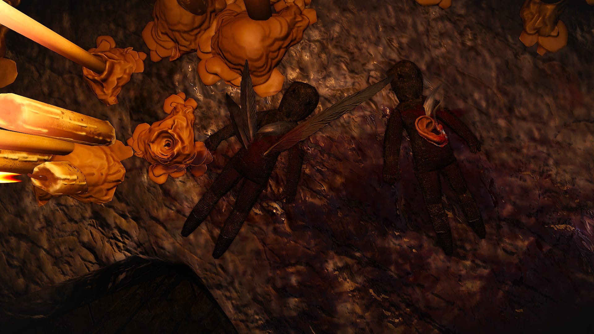 Two crude dolls covered in blood, feathers and a human ear