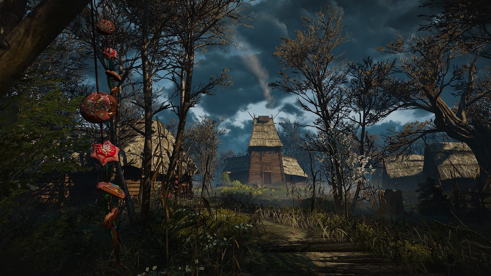 The house of the crones in the background, decorated gingerbread dangling from a tree in the foreground