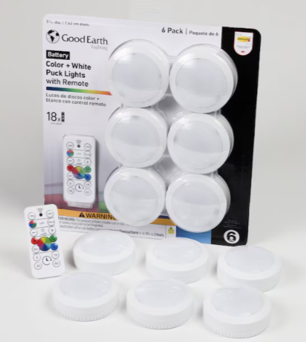 Six white puck-shaped LED lights with remote controls, showing battery-operated lights with color-changing capabilities