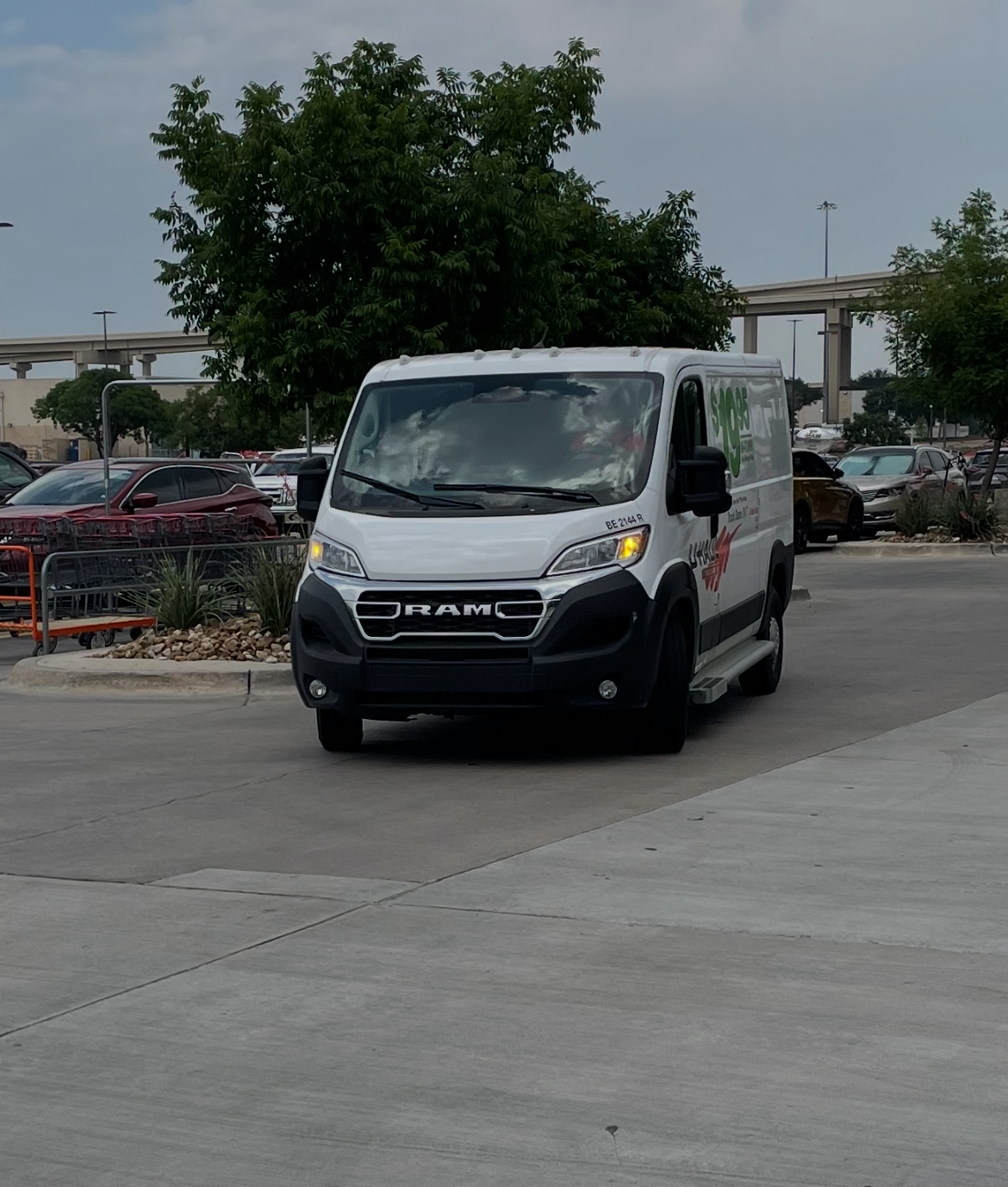 White RAM rental van parked in a store parking lot under cloudy skies, used to transport a TV that couldn't lay flat in a regular car.