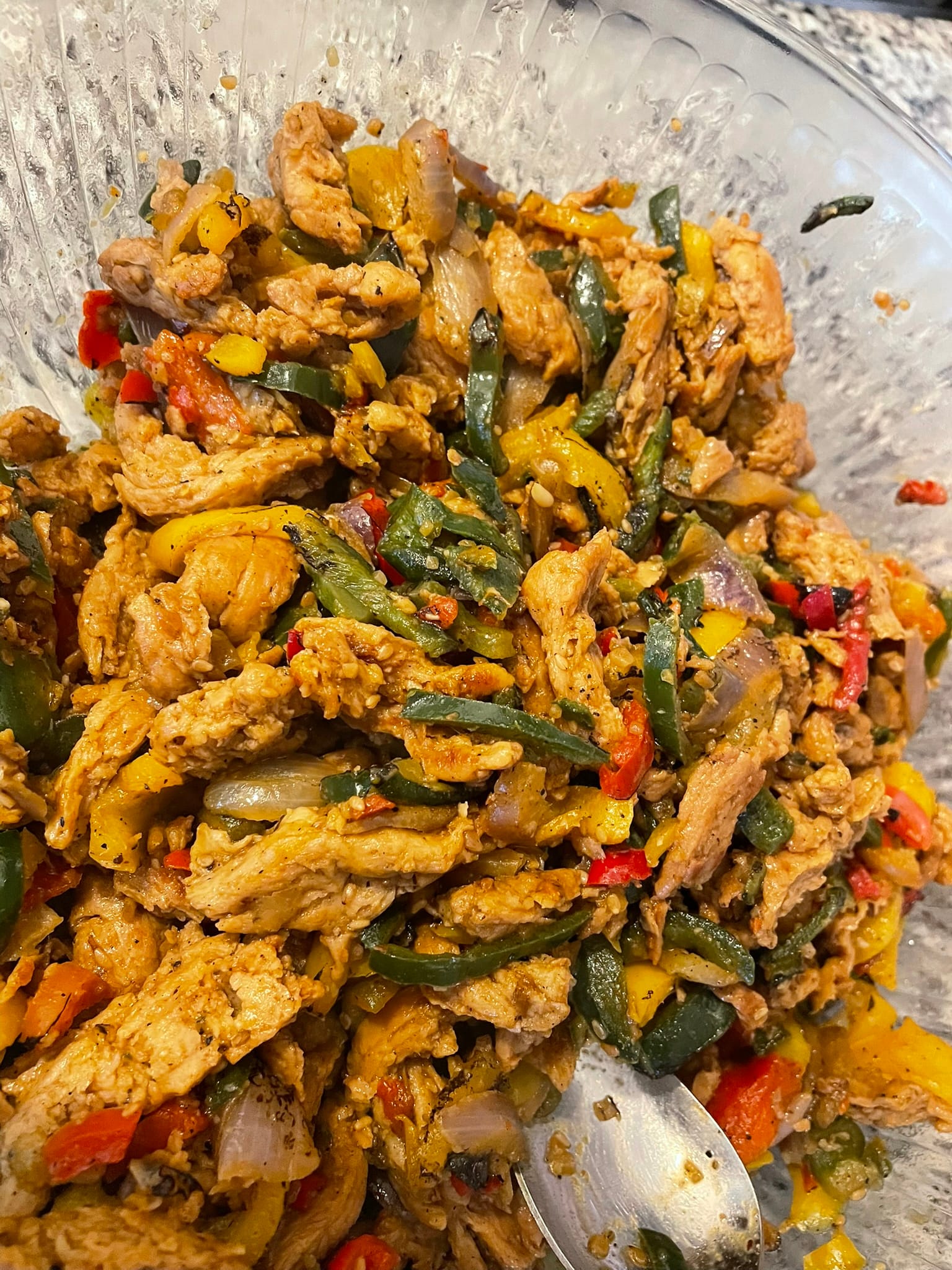 Glass bowl filled with colorful stir-fried vegetables and seasoned protein showing meal preparation for busy days ahead.