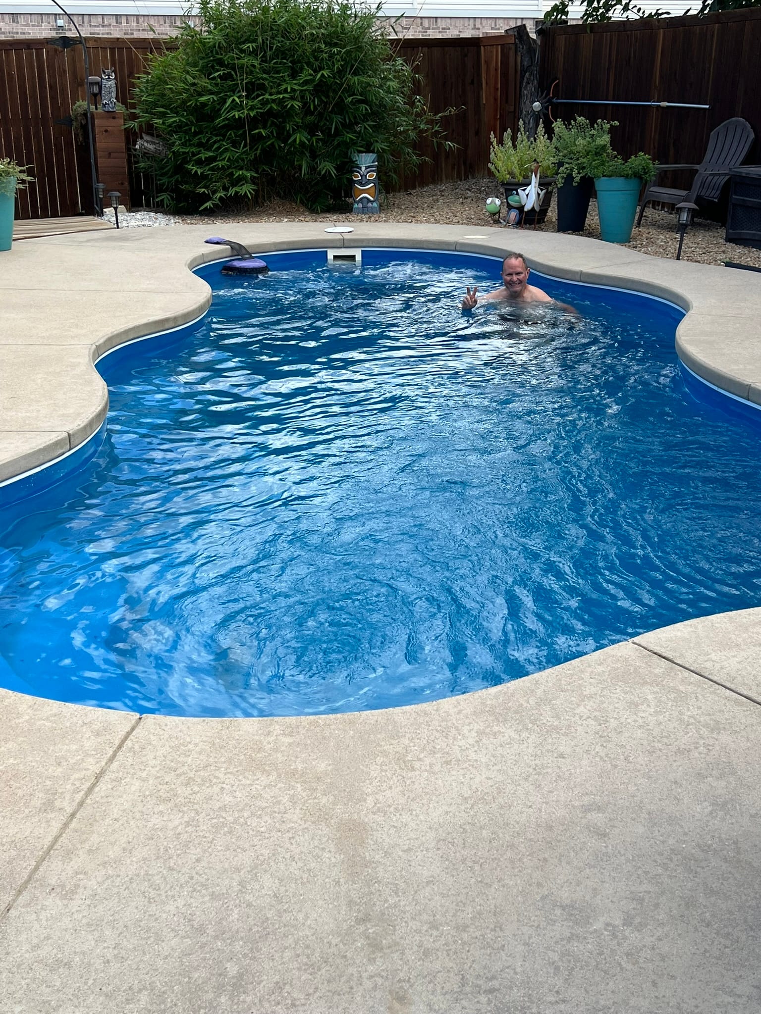 Bryan swimming in backyard pool during final swim before moving
