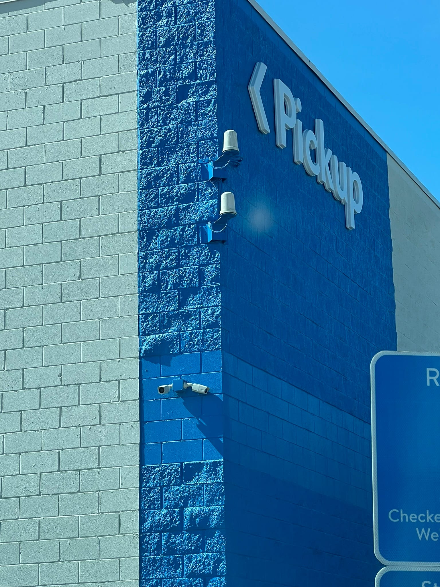 Walmart grocery pickup area with blue store signage and pickup lanes