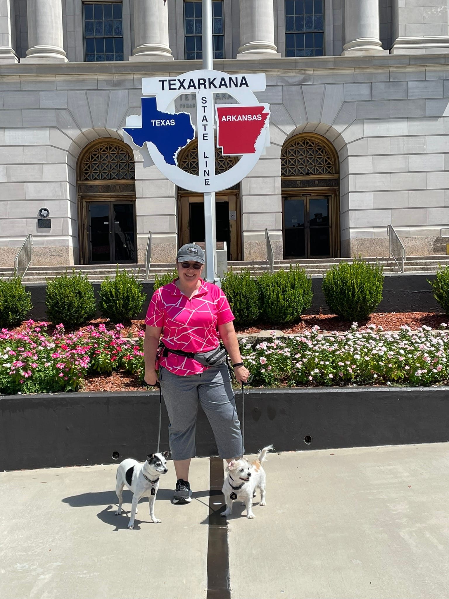 Woman with two dogs at Texarkana state line during 30th wedding anniversary road trip