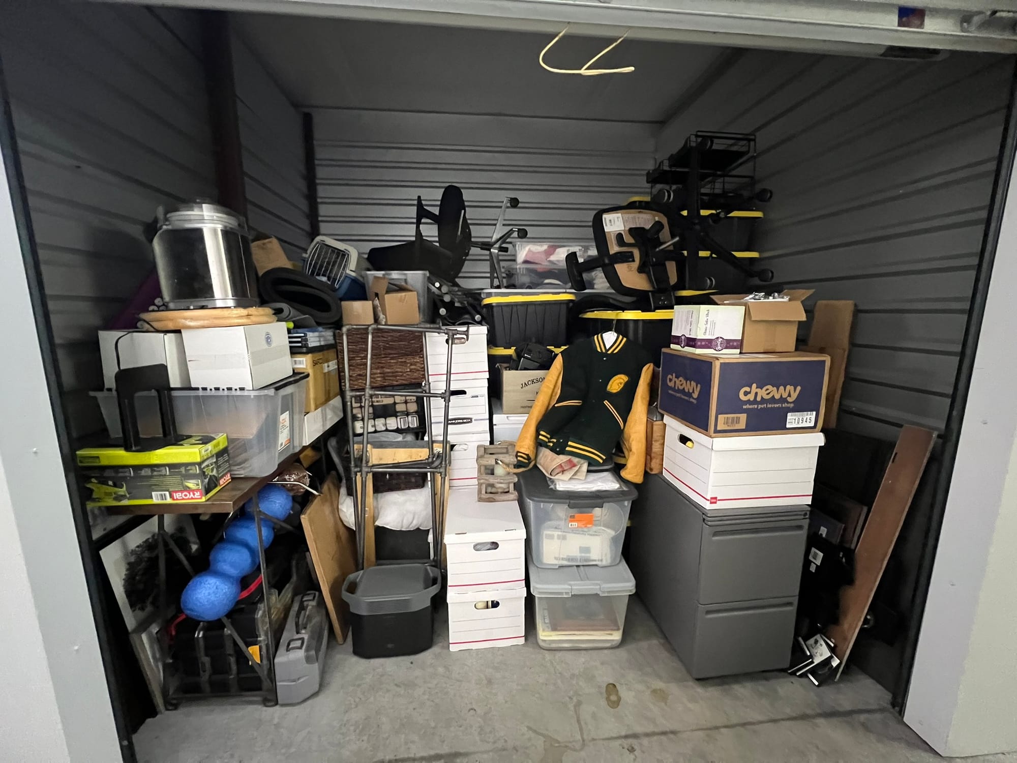 A photo of an organized storage unit filled with moving boxes and belongings, representing the chaotic state of living in between homes.