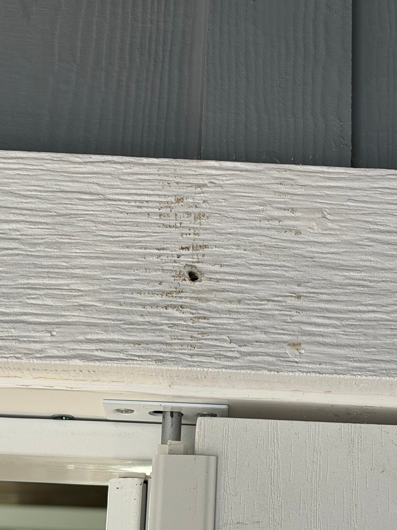 Hole in white trim board from removed transport fixture mounting hardware