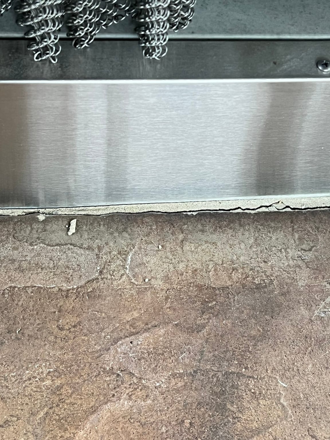 Missing and cracked grout between fireplace stones with visible gaps in seams