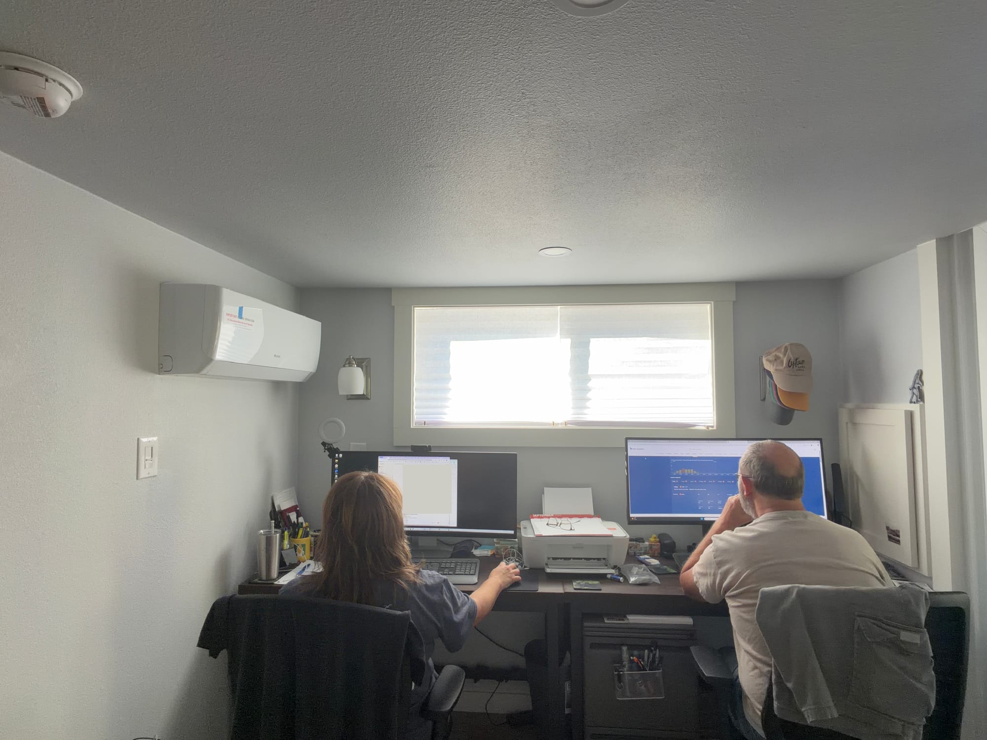 Kathy and Bryan working at their home office desks in their tiny house