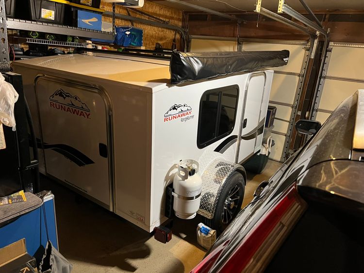 White Runaway camper with black accents fits "millimeter-perfect" in the garage