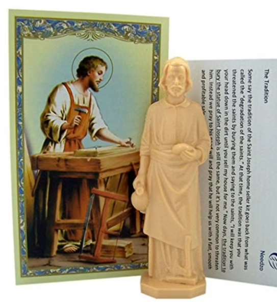 St. Joseph statue next to prayer card showing the patron saint of home and family, used in the traditional home selling ritual.