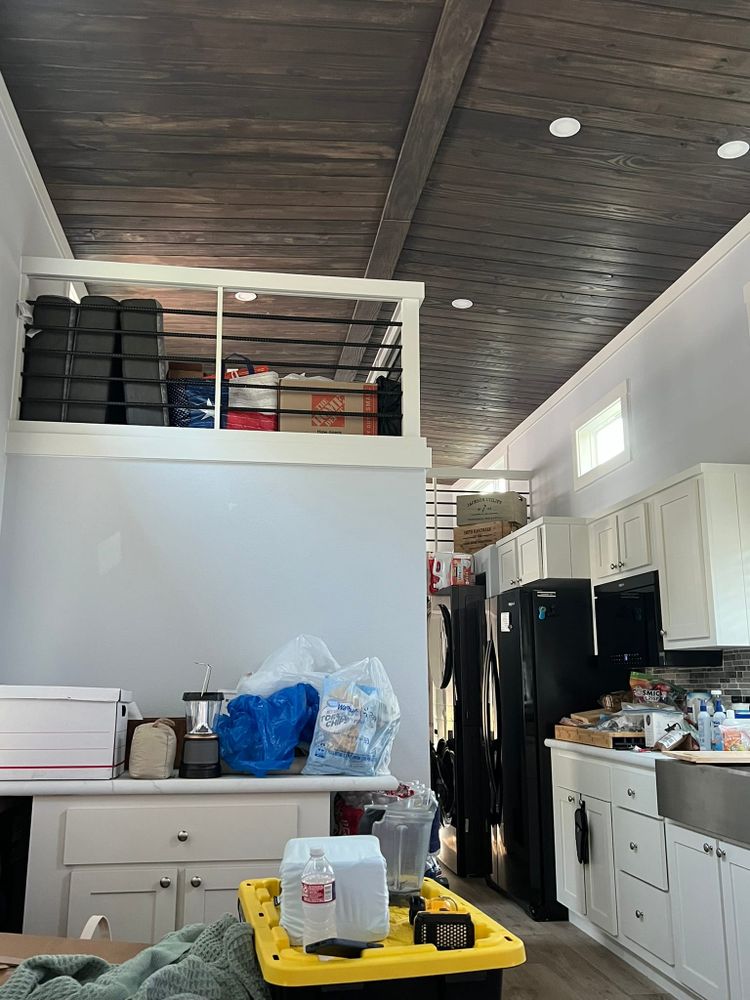 Cluttered tiny house interior with boxes and items staged throughout living space during moving week