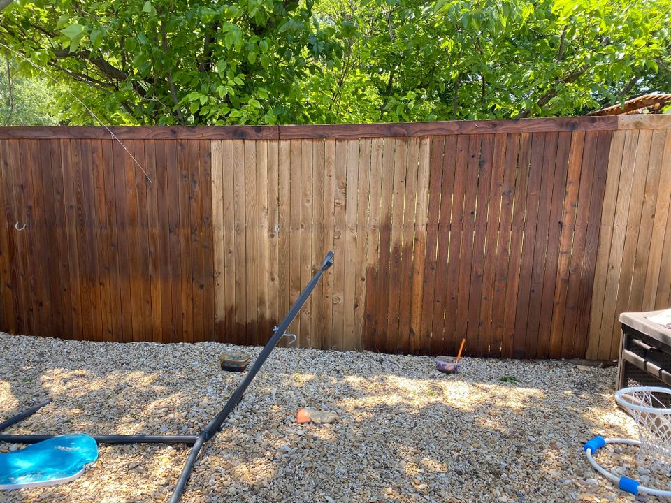 Half-stained backyard fence awaiting completion - a spring maintenance project we're ready to trade for adventures.