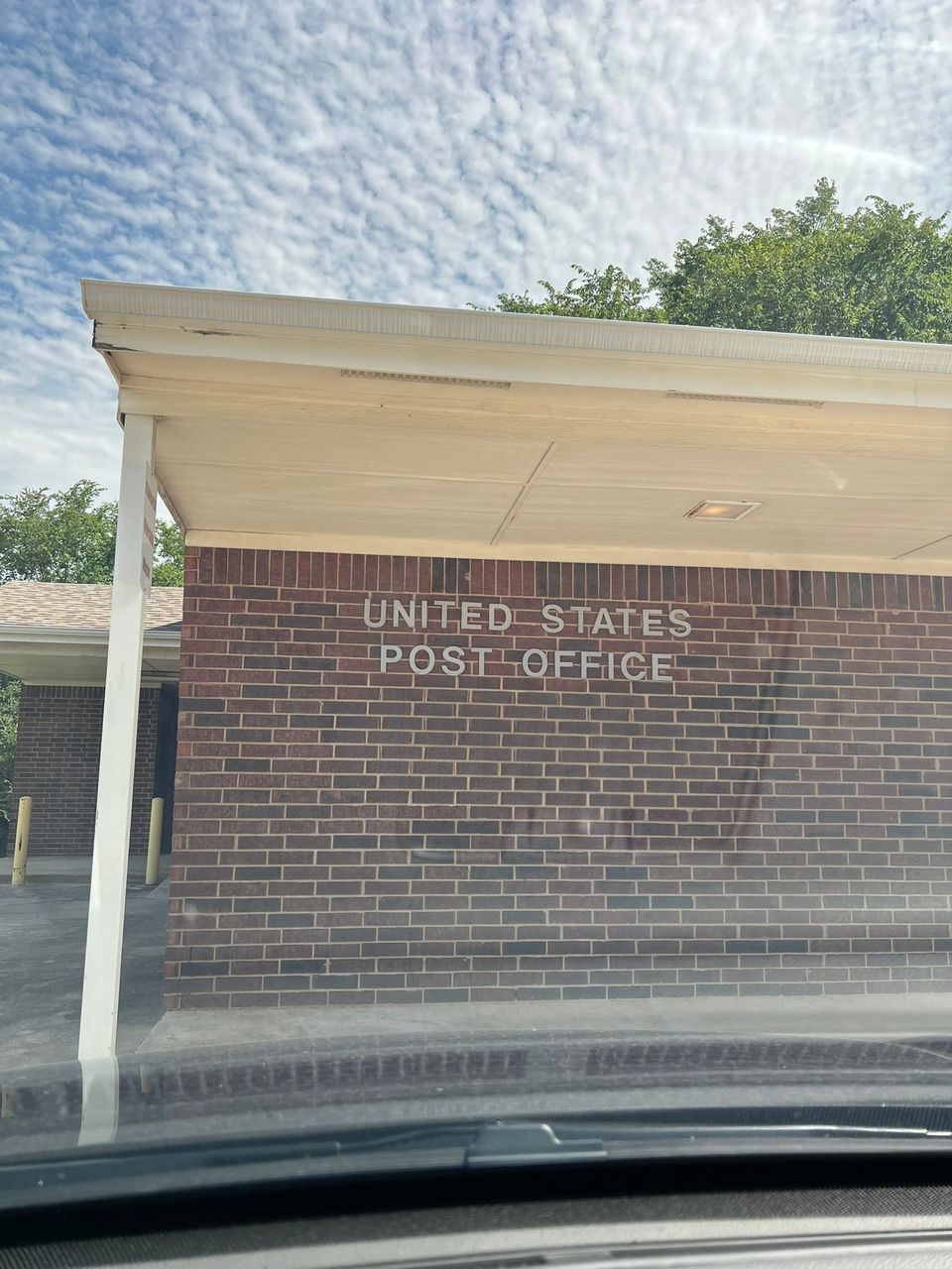 United States Post Office building with brick facade and white overhang.