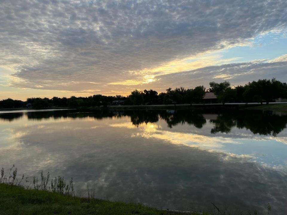 Peaceful lake reflection at sunrise in tiny home community showing the slower pace of Week 28