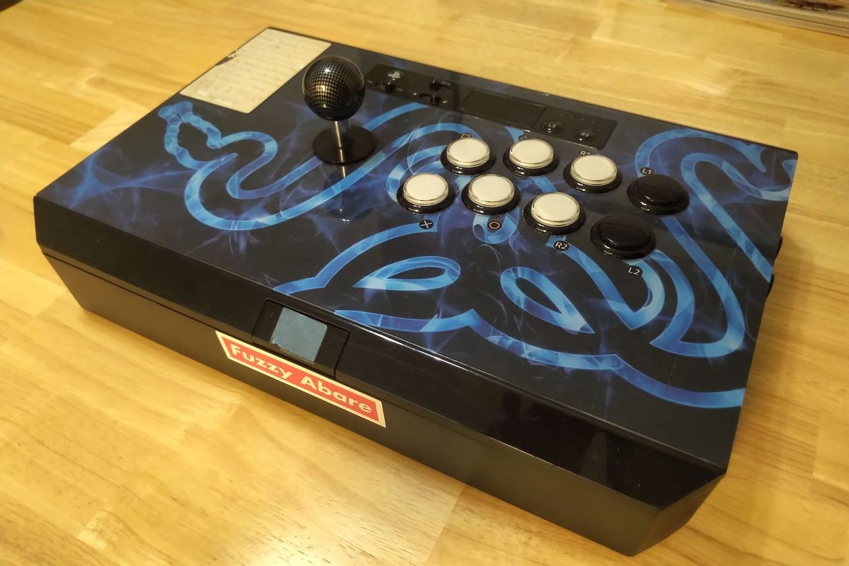 A Razer Panthera arcade stick with modified buttons and some decals with signs of wear.