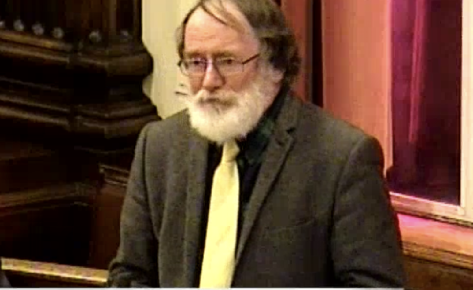 Screenshot Image from Wirral Council video of Cllr Brame standing and speaking at the meeting